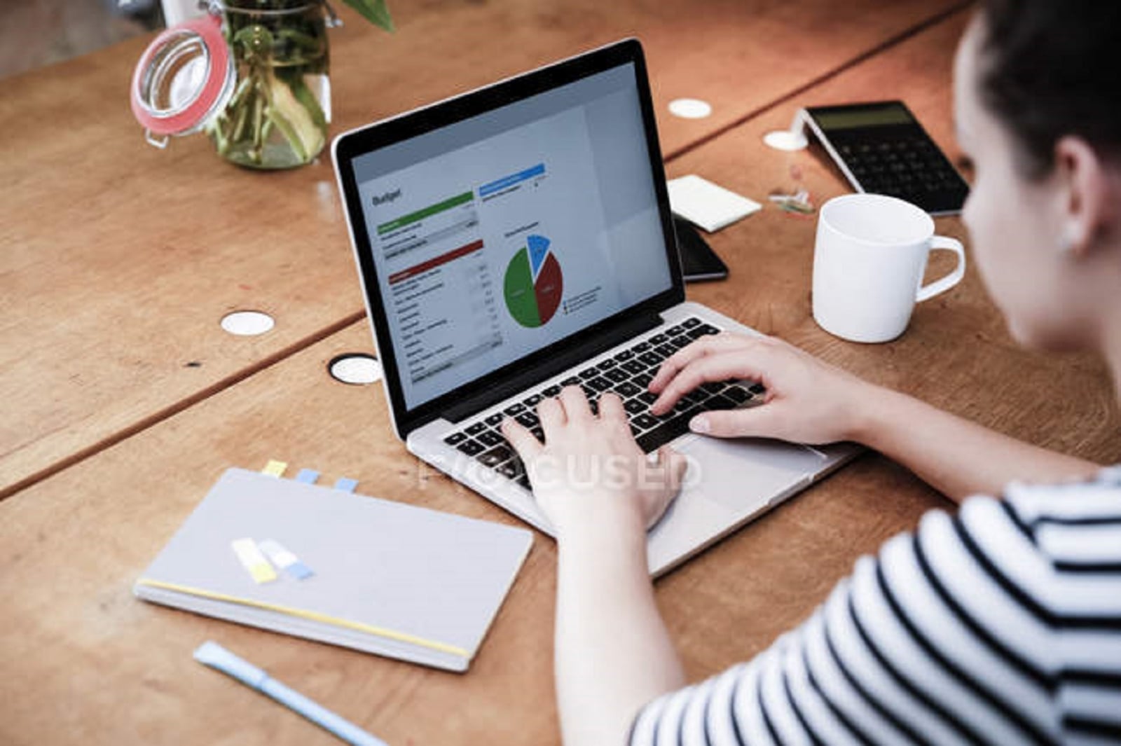 focused_173747406-stock-photo-woman-desk-using-laptop-working