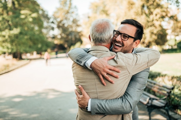 reunion-familiar-padre-e-hijo-abrazando-al-aire-libre_109710-401