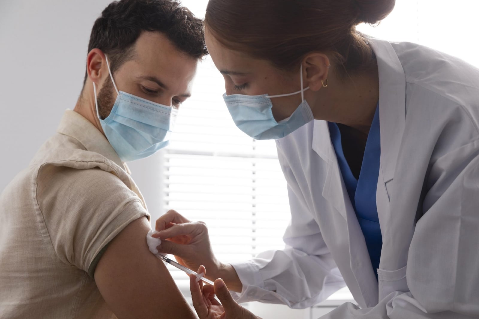 nurse-vaccinating-male-patient-scaled