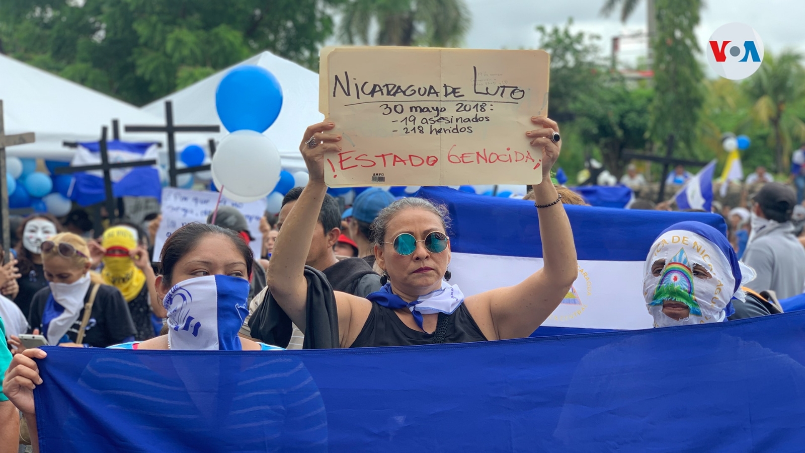 Una. mujer sostiene una pancarta en una protesta en Managua. Foto Houston Castillo, VOA