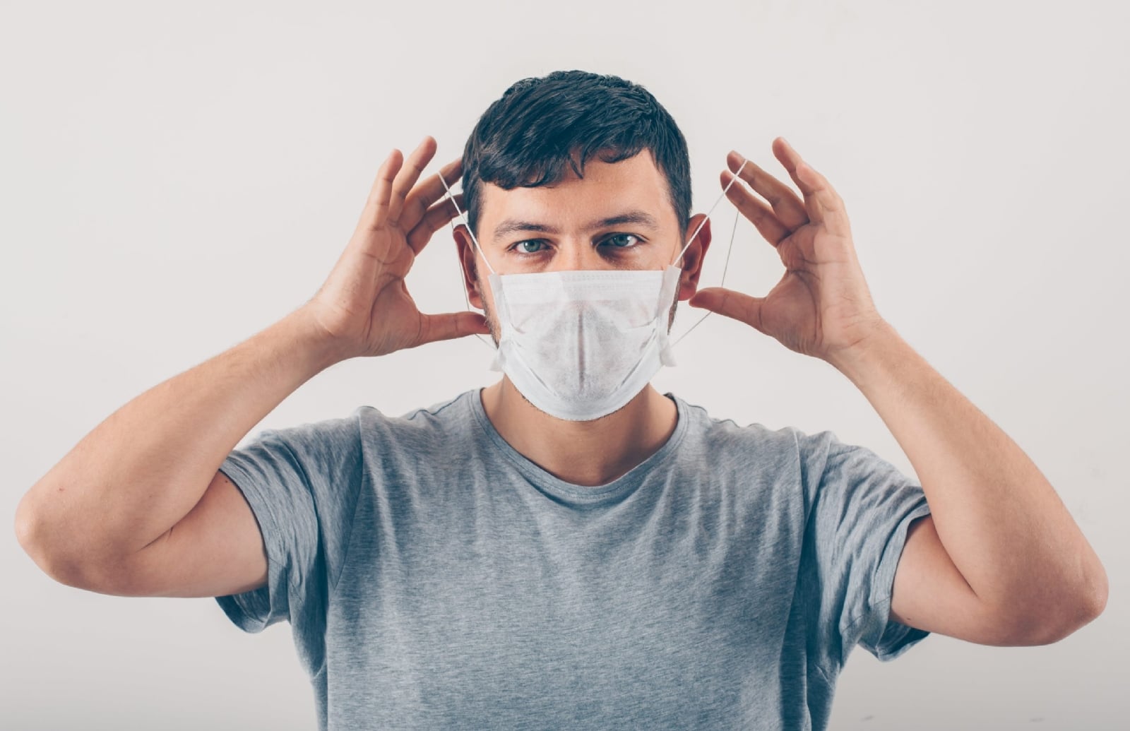 a-man-in-gray-t-shirt-wearing-medical-mask-in-white-background-min-scaled