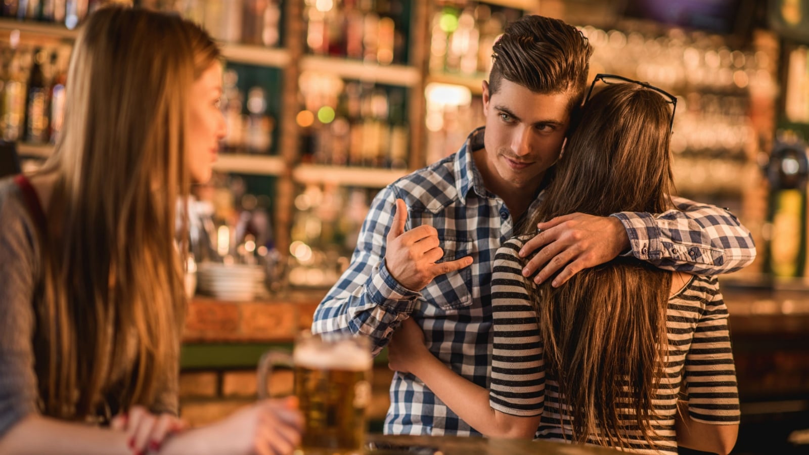 hombre-haciendo-senas-a-otra-chica-mientras-abraza-a-su-novio