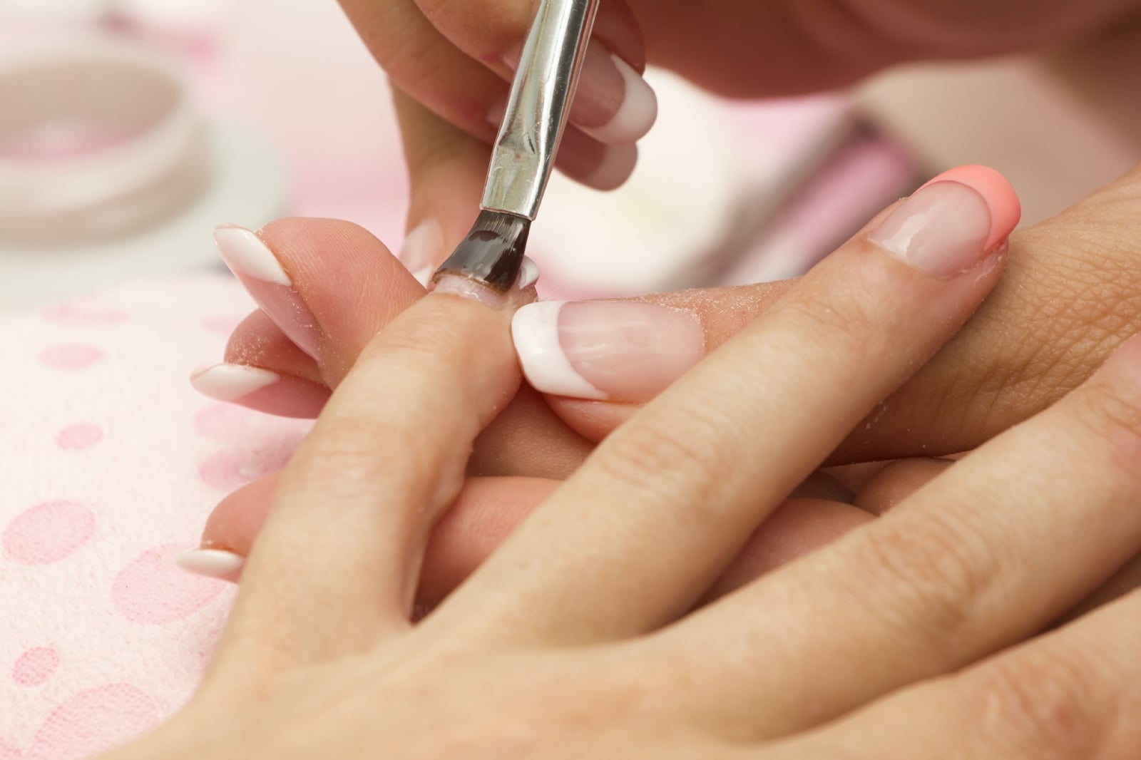 manicure-applying-nail-gloss-on-female-fingernails-royalty-free-image-583982984-1561210851