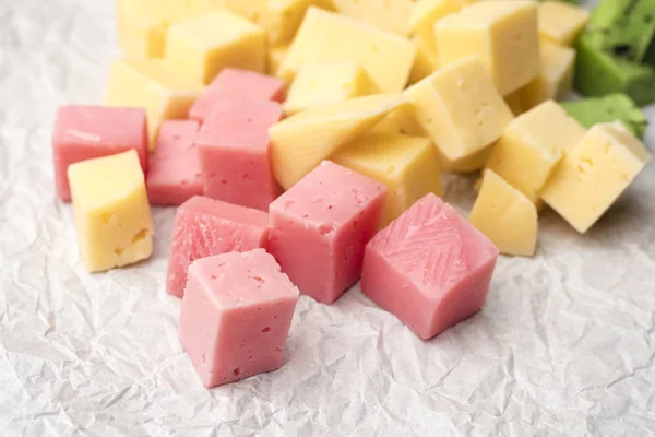 depositphotos_302772314-stock-photo-cheese-cubes-pink-yellow-crumpled