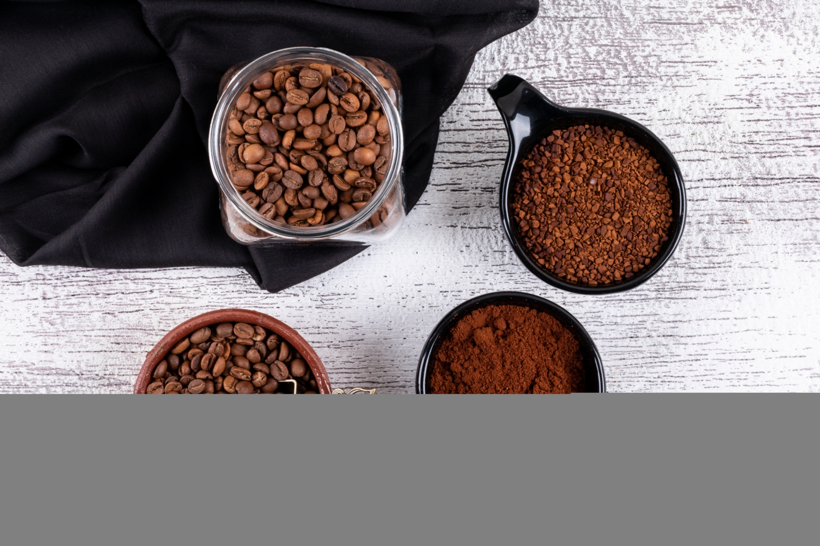 top-view-coffee-beans-and-instant-coffee-in-cups-on-white-table